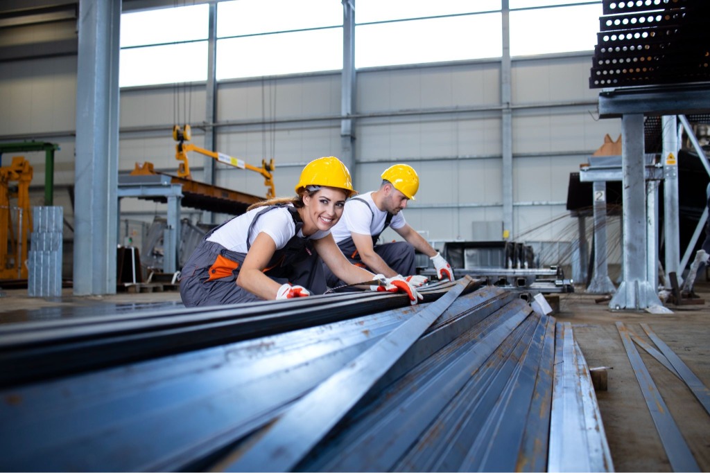 Workers setting down sheet metal